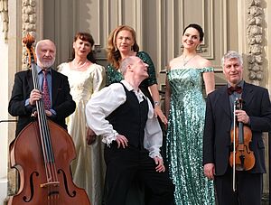 Das Ensemble Stretta Operetta auf einer Treppe vor einem historischen Haus. 