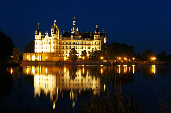 Das Schweriner Schloss bei Nacht. Das Schloss ist angestrahlt.