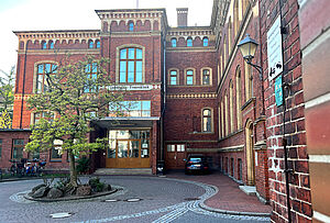 Ein Backsteingebäude mit der Aufschrift Universitäts-Frauenklinik an einem Sommertag.