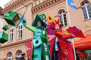 Zwei bunt verkleidete Personen auf dem Marktplatz.