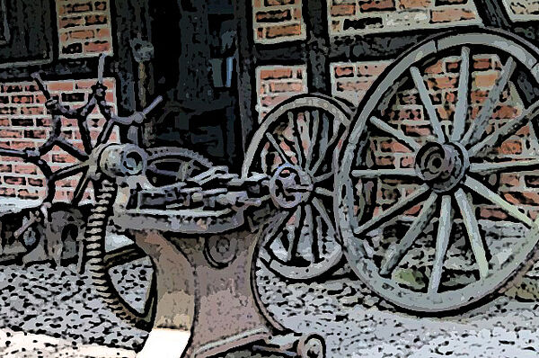 Symbolfoto einer historischen Schmiede. Zu sehen sind alte Werkzeuge und geschmiedete Erzeugnisse wie geschmiedete Wagenräder.