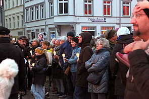 Blick ins Publikum. Einige Menschen halten Kerzen in den Händen.