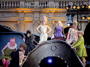 Eine Szene aus "Tartuffe oder Das Schwein der Weisen". Fünf Schauspielerinnen und Schauspieler stehen in Kostümen nebeneinander in der Kulisse. Eine Person trägt einen Schweinskopf als Maske.