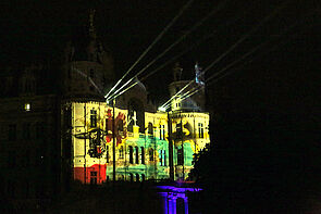 Das Schweriner Schloss in bunten Farben angestrahlt.