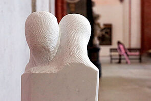 Kunst in der Kirche: Zwei Köpfe ohne Gesicht, eng zusammen. 